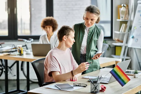 Facendo appello a diverse donne d'affari che lavorano insieme sul progetto in carica, bandiera dell'orgoglio. — Foto stock