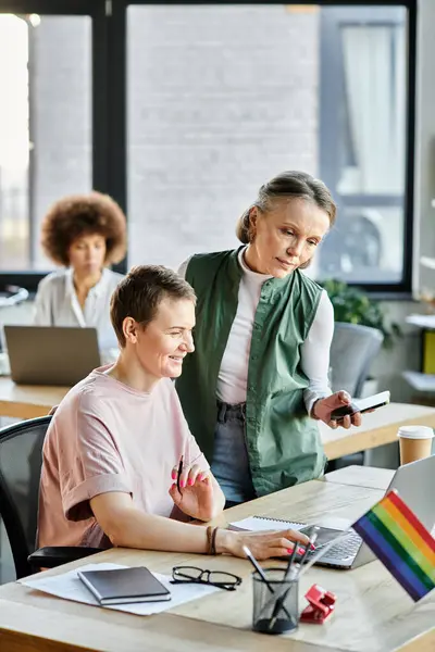 Jolly diversas empresarias que trabajan juntas en el proyecto en la oficina, bandera del orgullo. — Stock Photo