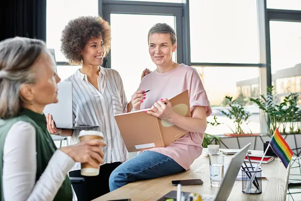 Diverse, hardworking businesswomen engage in a lively discussion at a table. — Stock Photo