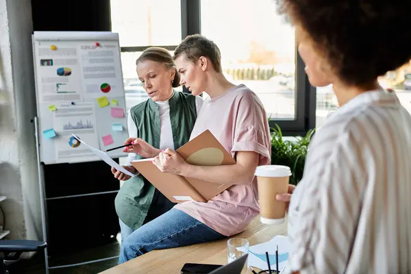 Diverse fleißige Geschäftsfrauen versammelten sich um einen Tisch in einem Coworking Space. — Stockfoto