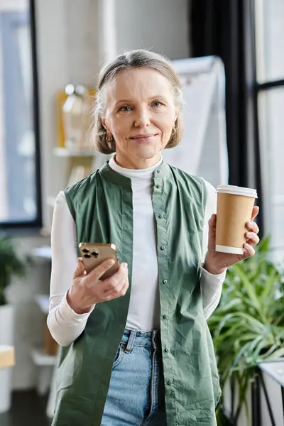 Бізнес-леді тримає чашку кави і телефон. — стокове фото