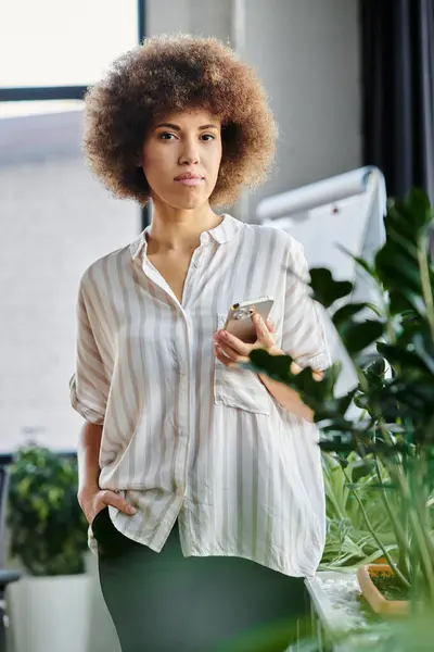 Femme d'affaires tenant un téléphone portable dans le bureau. — Photo de stock
