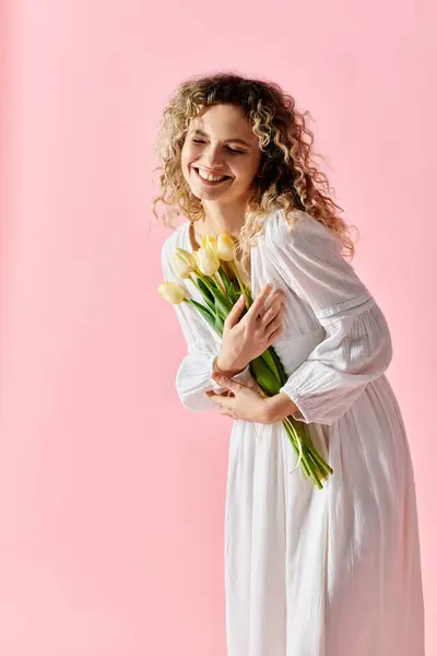 Woman in white dress holding tulip bouquet. — Stock Photo