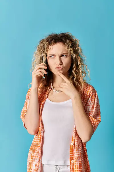 Jeune femme aux cheveux bouclés parlant sur téléphone portable sur fond coloré. — Photo de stock