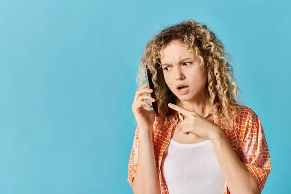 Eine junge Frau mit lockigem Haar spricht auf einem Handy. — Stockfoto