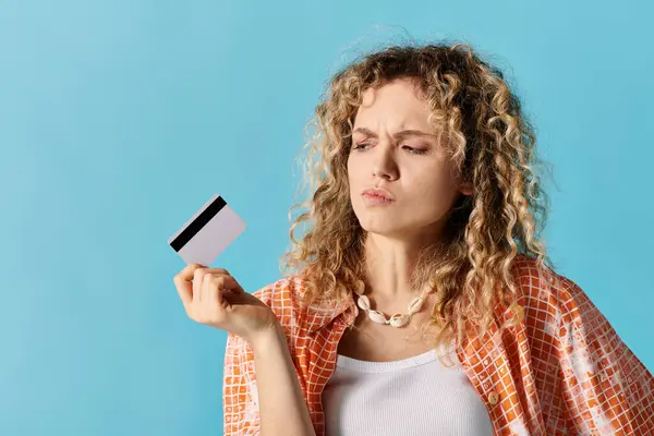 Woman with curly hair confidently displaying a credit card. — Stock Photo