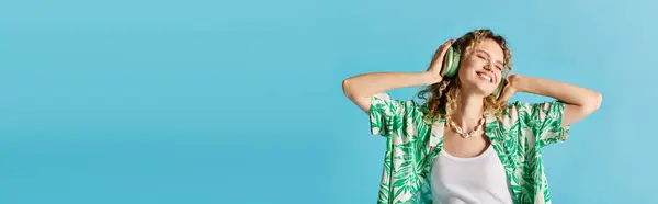 Кучерява жінка в зеленій гавайській сорочці виявляє елегантність на синьому фоні. — стокове фото