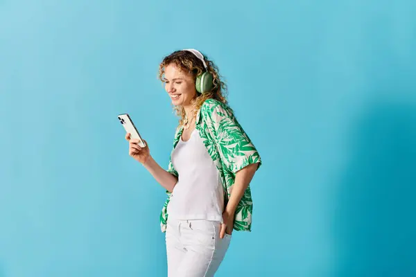 Uma mulher com fones de ouvido, desfrutando de música em seu telefone. — Stock Photo