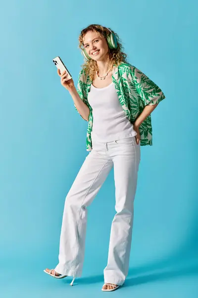 Mulher elegante em calças brancas e camisa verde segurando um telefone celular. — Fotografia de Stock