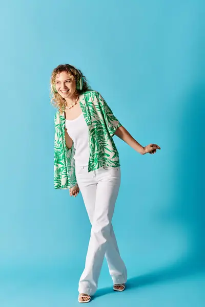 Stylish woman with curly hair posing in trendy outfit on bright blue backdrop. — Stock Photo