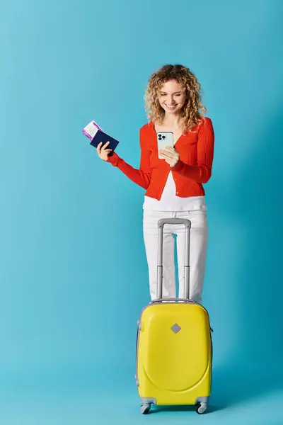 Femme avec valise jaune et téléphone portable — Photo de stock