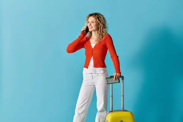 Woman multitasking with phone and suitcase — Stock Photo
