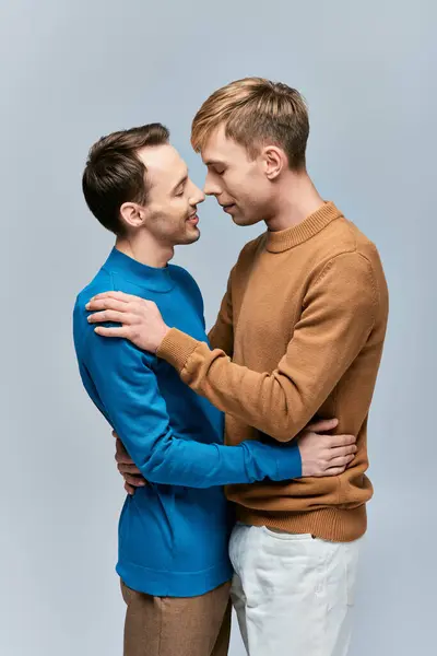 Two men in casual attire embracing in a loving stance. — Stock Photo