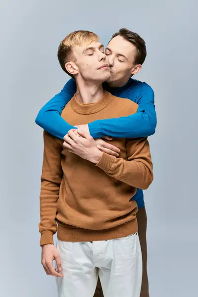 Dos hombres, una pareja gay amorosa, se abrazan con sus brazos alrededor, mostrando unidad y conexión. - foto de stock