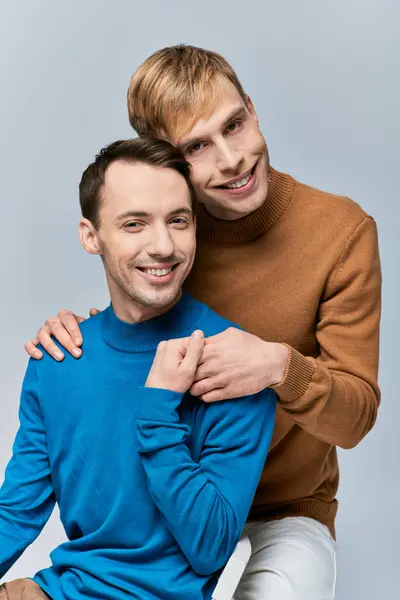 Two men in casual attire seated and smiling at the camera. — Stock Photo