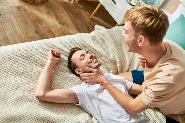 Two men, a loving gay couple, relax on a couch in casual attire. — Stock Photo