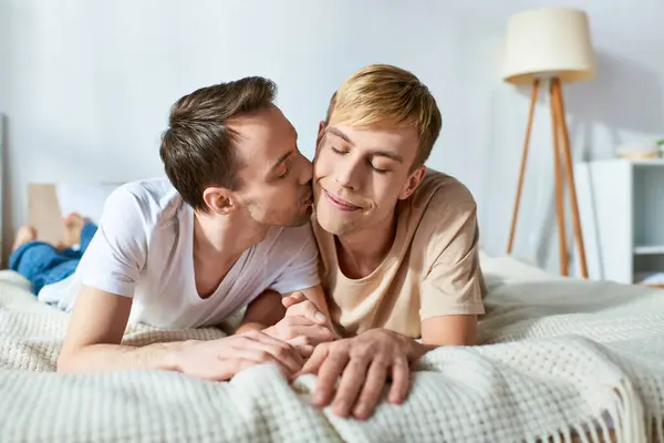 Two men laying on a bed, sharing a passionate kiss. — Stock Photo