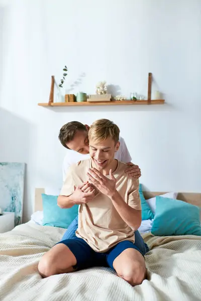 Dois homens vestidos casualmente sentados em uma cama, compartilhando um momento tranquilo. — Stock Photo