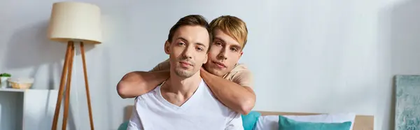 Loving gay couple in casual attire cuddling in a cozy room. — Stock Photo