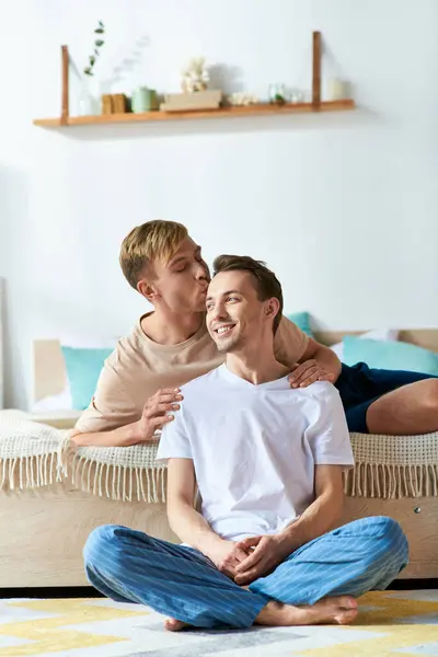 Two men sit on a bed, enjoying each others company in a cozy setting. — Stock Photo