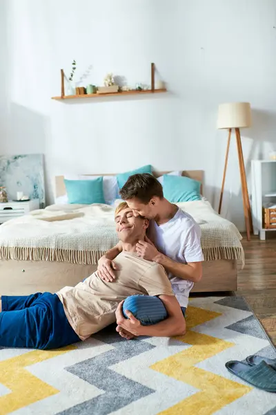 Two men relax on a rug in a bedroom. — Stock Photo