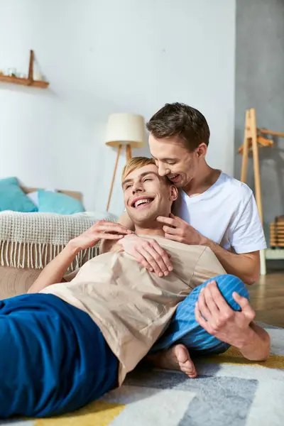 Ein Mann liegt auf dem Boden neben einem anderen Mann in legerer Kleidung und drückt seine Zuneigung aus. — Stockfoto