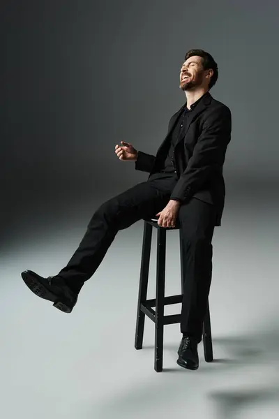 A man in elegant attire sits atop a stool. — Stock Photo