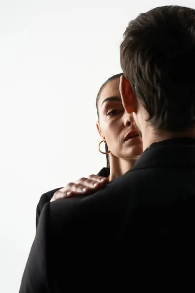 Um homem e uma mulher posam juntos em trajes elegantes. — Fotografia de Stock