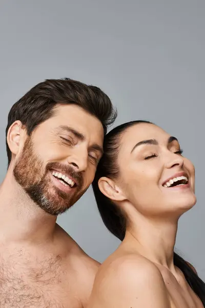 Um homem e uma mulher riem juntos em um momento de alegria compartilhada. — Fotografia de Stock