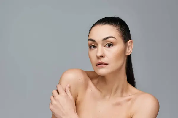 Mulher atraente com cabelos muito longos fica no fundo branco. — Fotografia de Stock