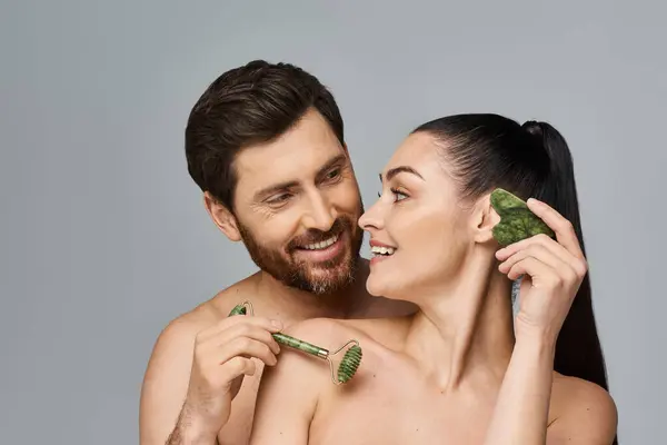 A portrait of an attractive couple applying skincare. — Stock Photo