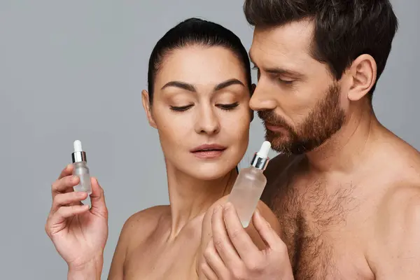Чоловік і жінка використовують сироватку як догляд за шкірою. — стокове фото