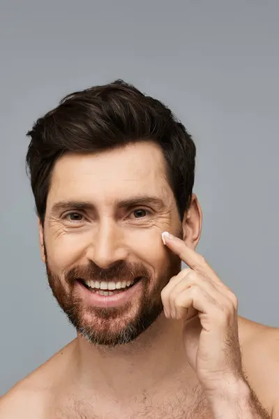 Handsome man applying cream. — Stock Photo