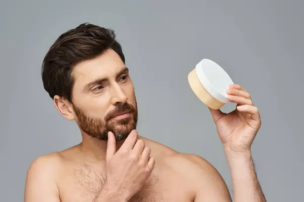 Shirtless man with cream container, skin care regimen. — Stock Photo