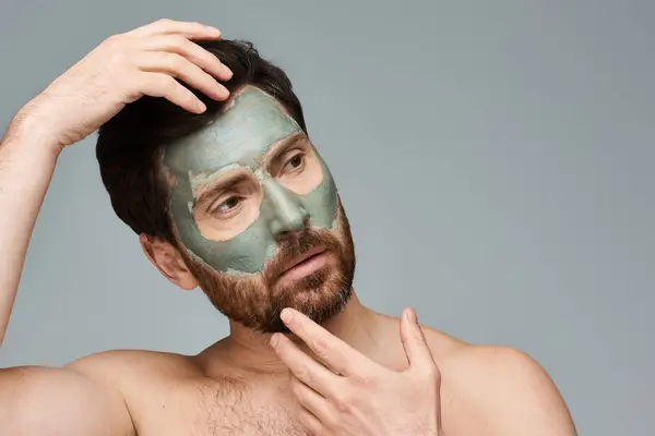 Handsome man applying a facial mask. — Stock Photo