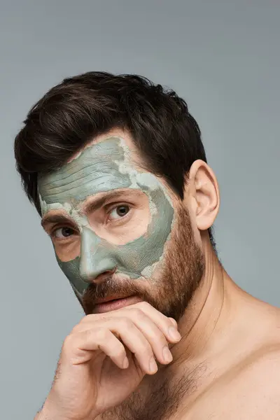 Ein Mann mit Gesichtsmaske, der seine Hautpflege verbessert. — Stockfoto