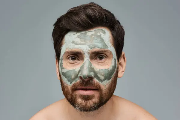 Homem barbudo usando uma máscara facial, cuidados com a pele. — Fotografia de Stock
