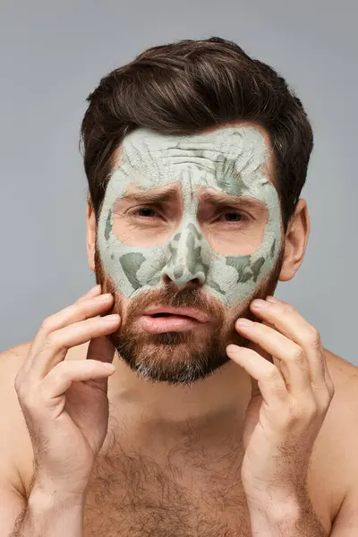 Un uomo che indossa una maschera facciale per il trattamento della cura della pelle. — Foto stock