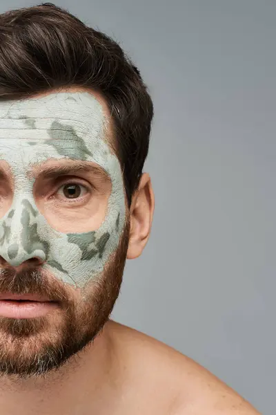 Homem bonito vestindo uma máscara facial, cuidados com a pele. — Fotografia de Stock
