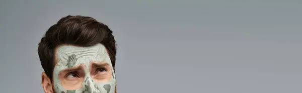 Apelando a un hombre elegante con una máscara facial, cuidado de la piel. - foto de stock
