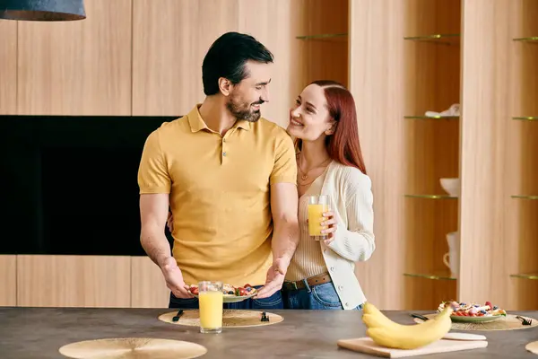 Una rossa e un uomo barbuto in piedi in una cucina piena di banane, trascorrendo del tempo di qualità insieme a casa. — Foto stock