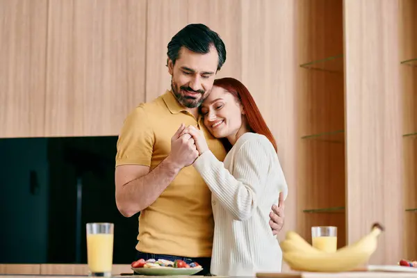 A redhead woman and bearded man passionately embrace in a modern kitchen, showcasing love and togetherness. — Stock Photo