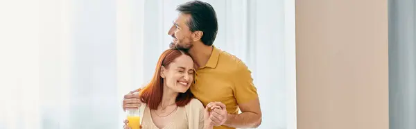Redhead woman and bearded man share a heartfelt hug, basking in the warmth of their love in a modern apartment. — Stock Photo