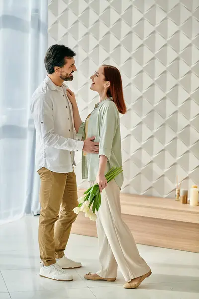 A bearded man and a redhead woman stand together in a modern apartment, exuding love and connection. — Stock Photo