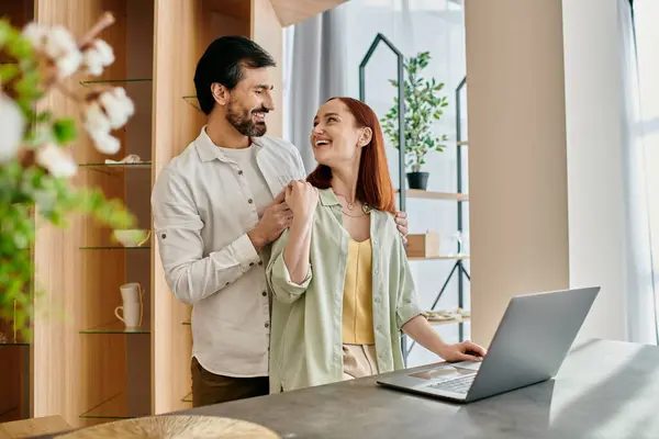 A stylish couple works together on a laptop in their chic kitchen, collaborating on culinary creations. — Stock Photo