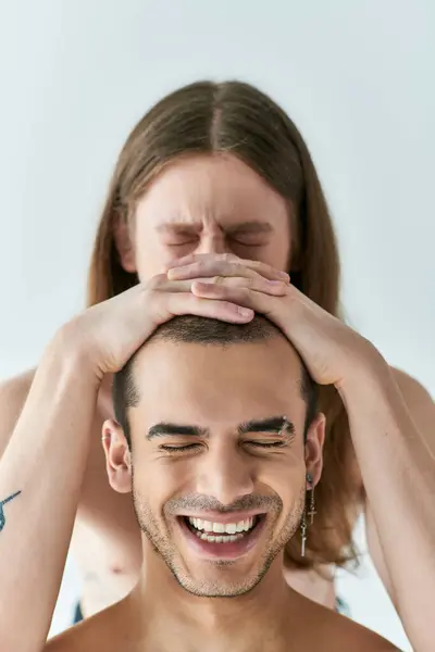 Um homem com um sorriso radiante com as mãos dos namorados na cabeça. — Fotografia de Stock