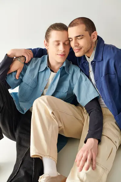 Due giovani uomini seduti vicini, che condividono un momento di connessione. — Foto stock