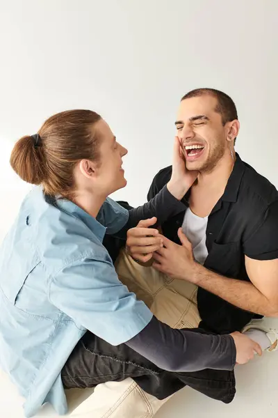 Zwei Männer sitzen auf dem Boden und lachen gemeinsam. — Stockfoto