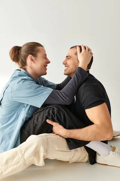 Two men sitting closely on the floor, sharing a moment of intimacy and connection. — Stock Photo