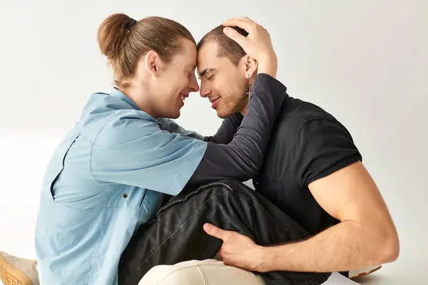 A gay couple sitting closely on the floor, expressing love and intimacy. — Stock Photo